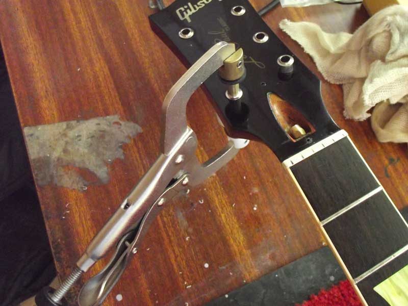Inserting tuner bushings with a Stewmac bushing press